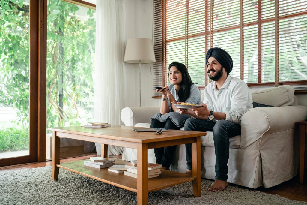 Couple Enjoying a Meal and Watching TV in Living Room Market to Thrive! Thrive with marive