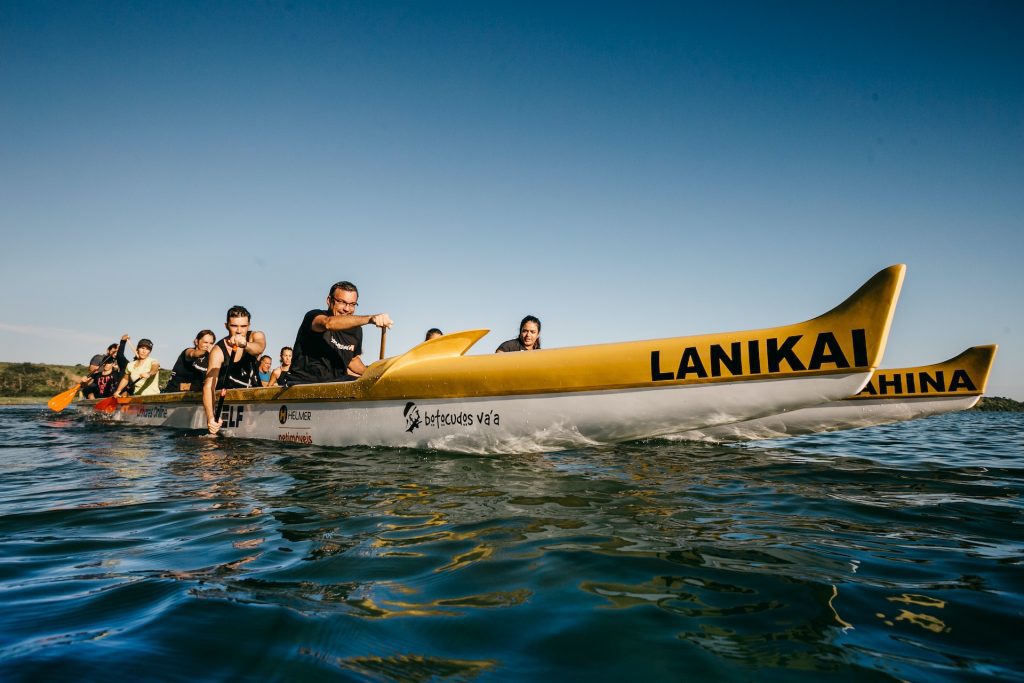 Team Paddling in Outrigger Canoe on a Clear Day Market to Thrive! Thrive with marive